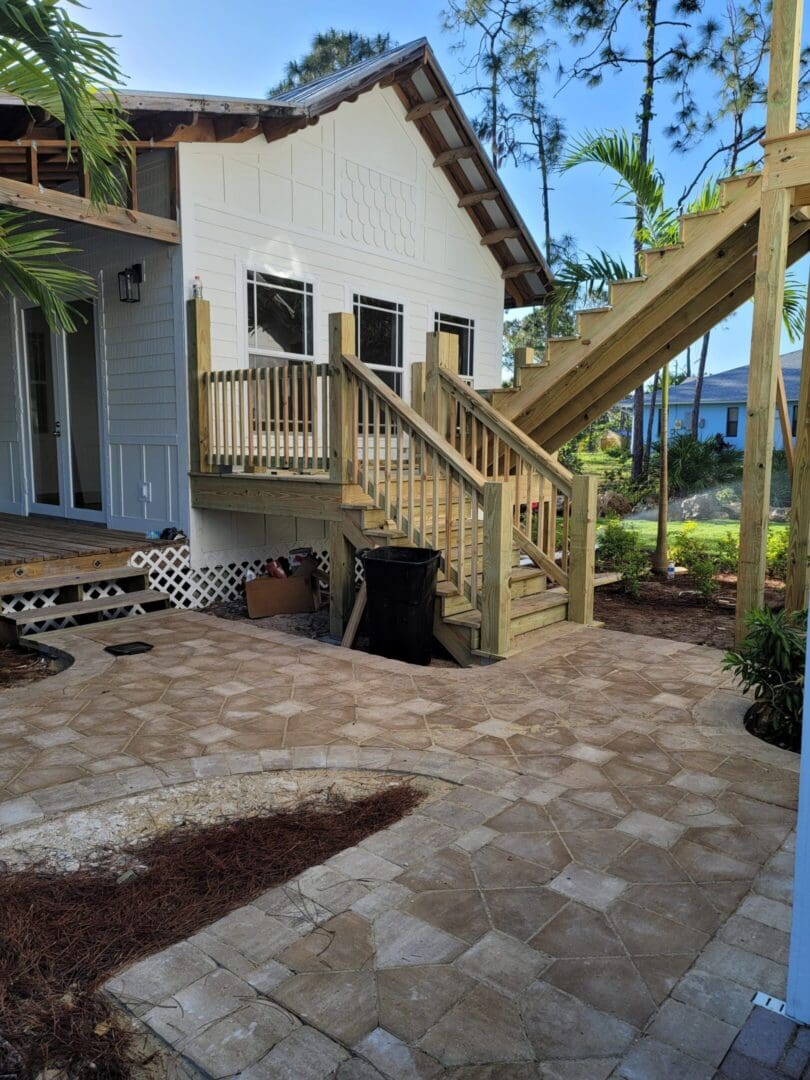 A patio with stairs leading to the back of the house.