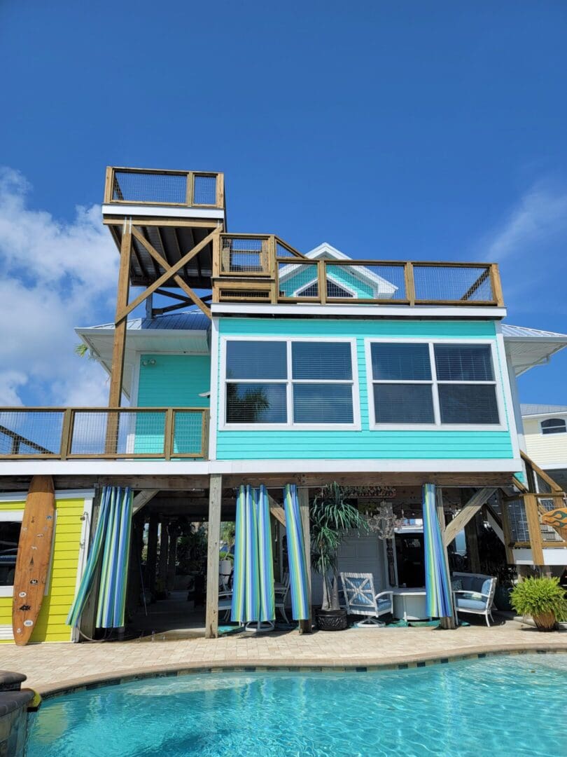 A house with a deck and chairs on the front of it.