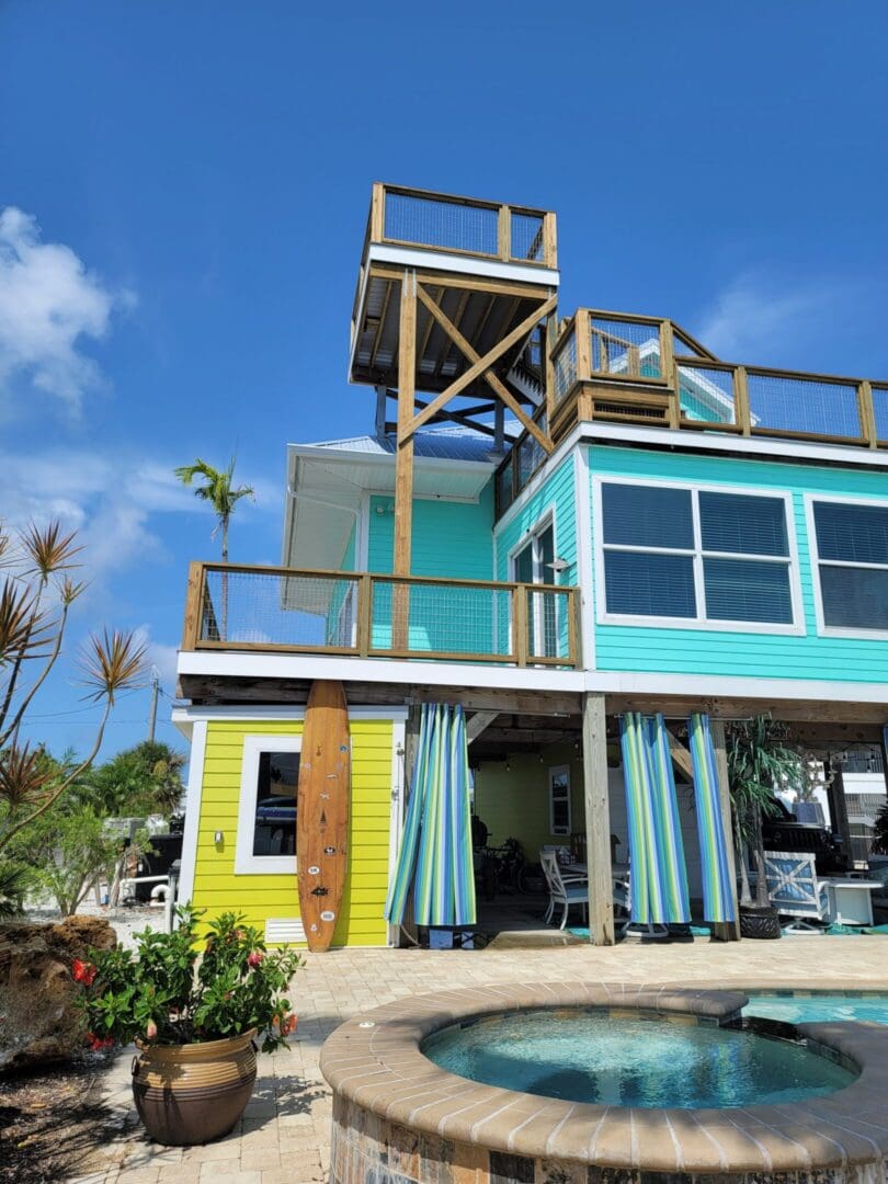 A colorful house with a deck and pool in the background.